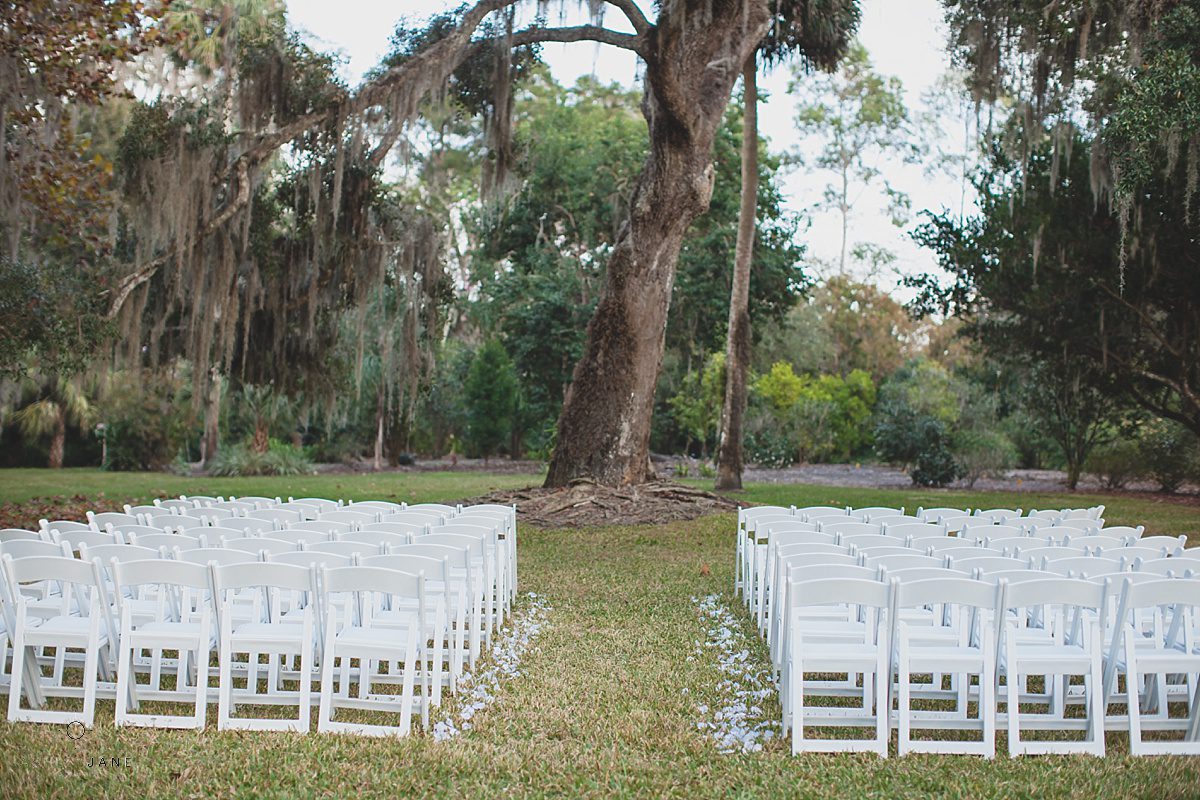 outdoor ceremony oak tree white chairs white rose petals