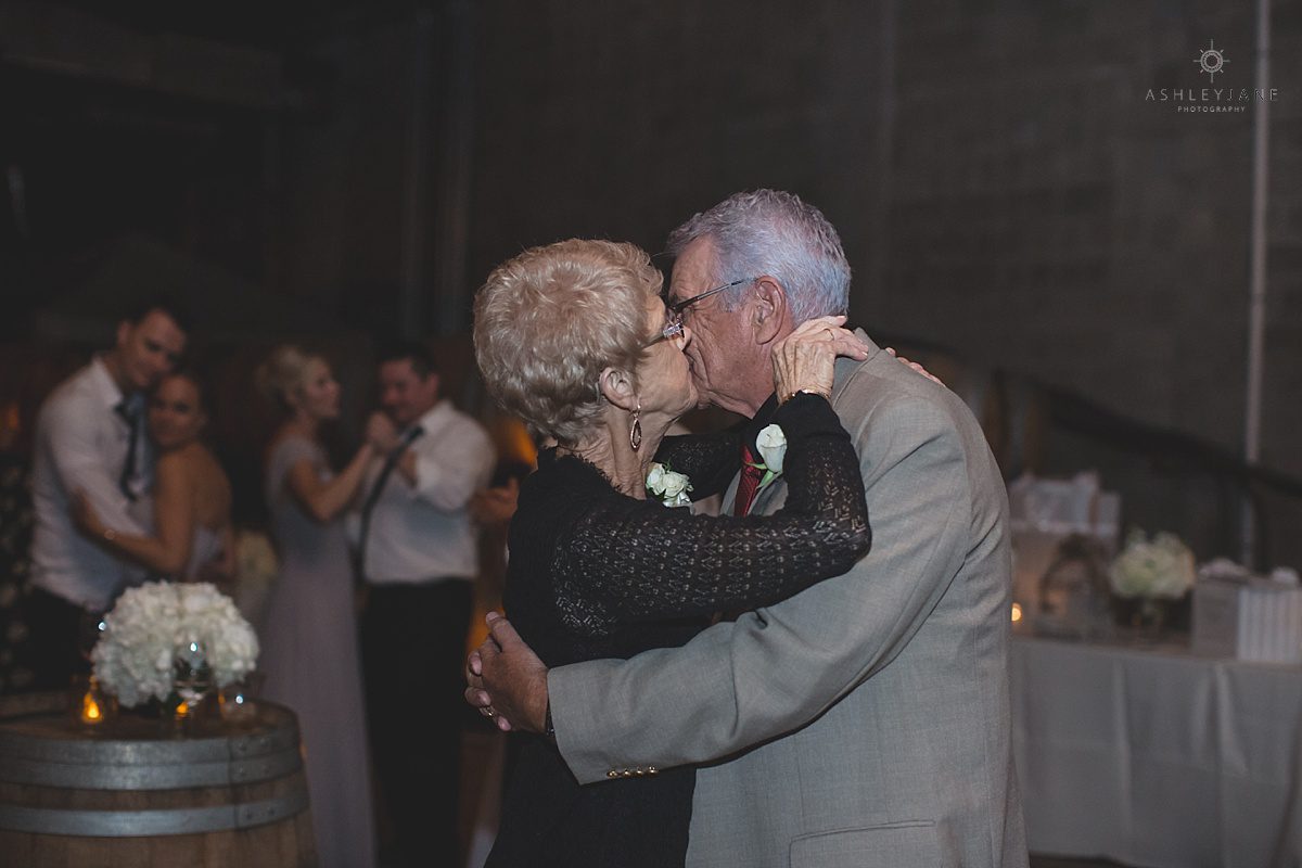 sweet moment between bride and grooms family slow dancing during wedding reception