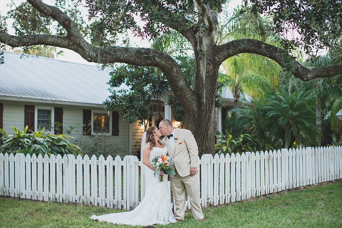 bride and groom share a kiss in front of their cottage