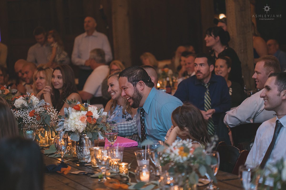 friends and family laughing during wedding reception toasts