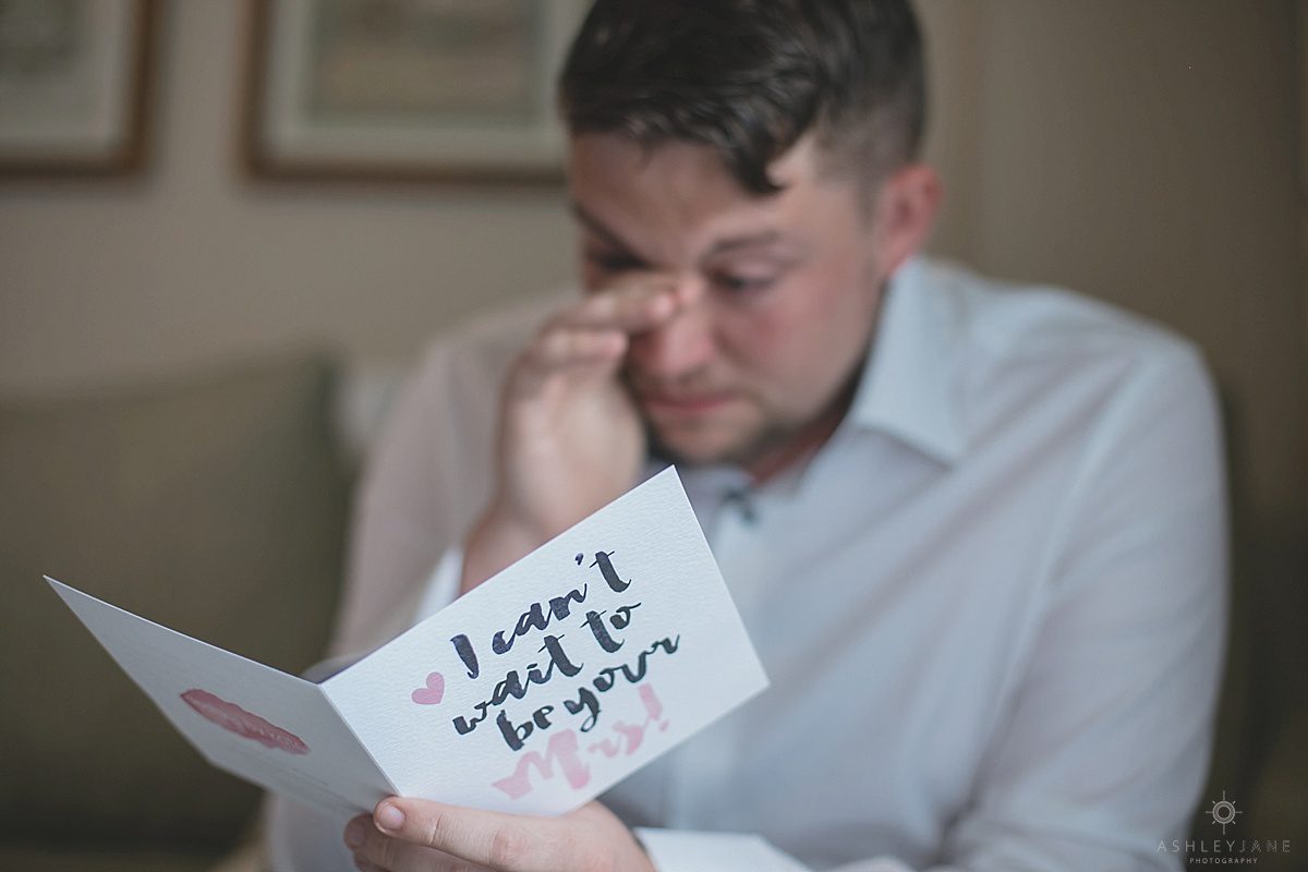groom before wedding reading a letter from his bride