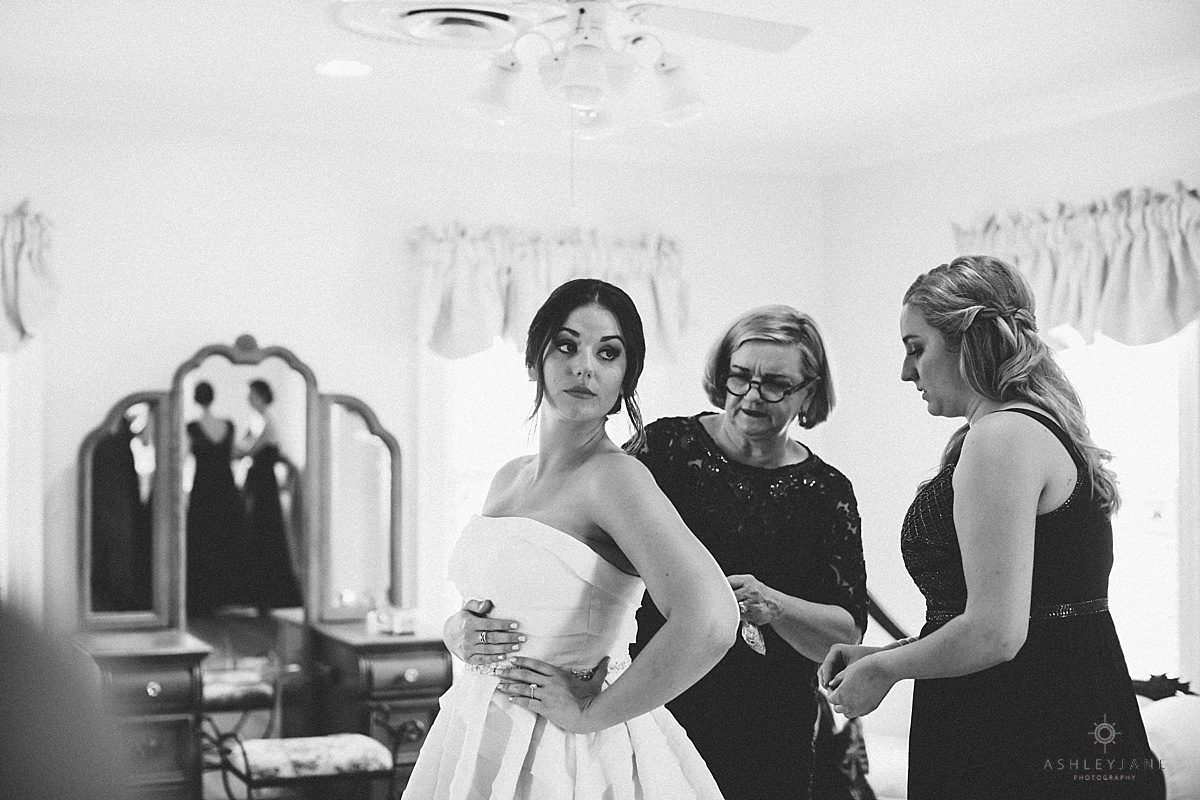 Bride getting buttoned in her gown caught by orlando wedding photographer