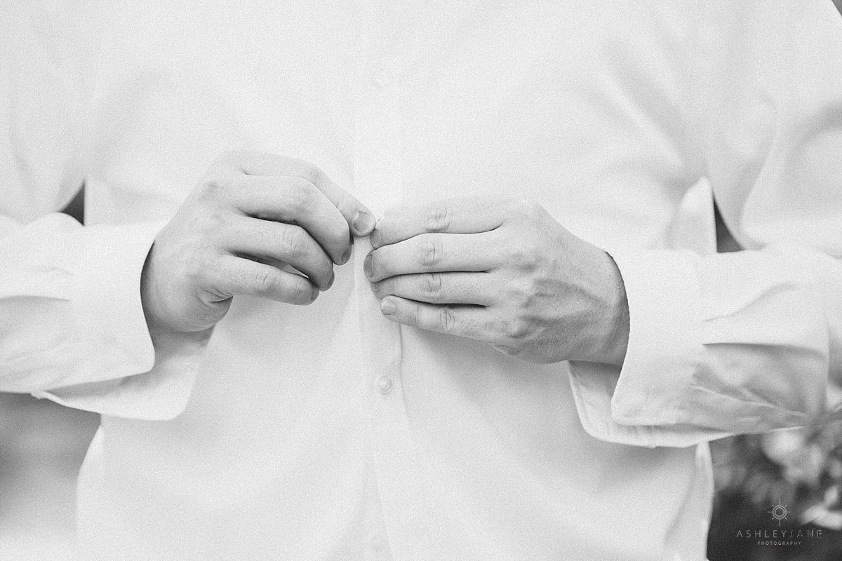Groom getting buttoned up shot by orlando wedding photographer