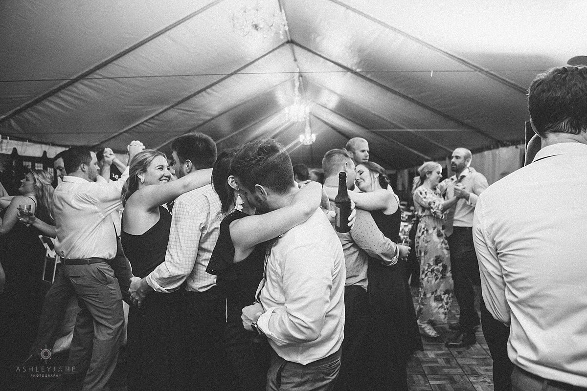 Guests dancing under Southern Estate House Wedding tent on grand lawn of Cypress Grove Estate House shot by orlando wedding photographer