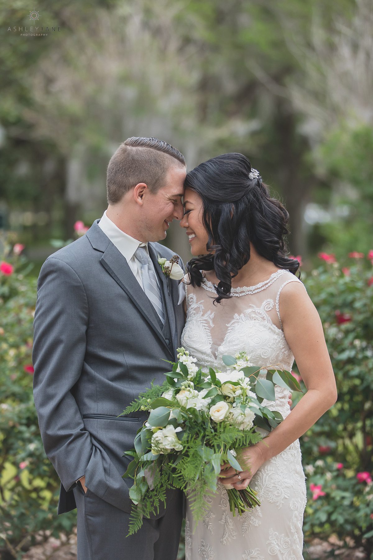 Bride and groom getting snuggled up in the rose garden of Cypress Grove Estate for their Al Fresco Lakeside Wedding 