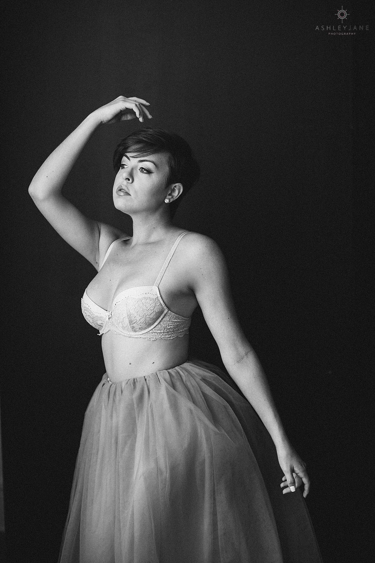 Model in cream lace bra and blush tulle skirt for elegant boudoir shoot caught by orlando boudoir photographer