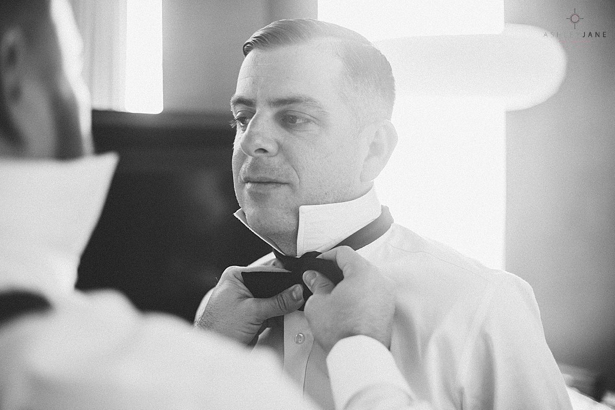 Groom getting in his tux and a shot of his accessories shot by orlando wedding photographer