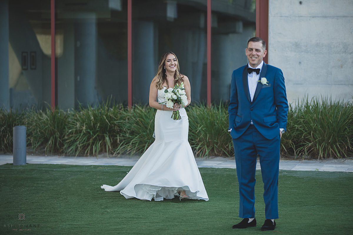 Bride walking towards her groom during their first look at the Clubhouse at Streasong Red caught by orlando wedding photographer