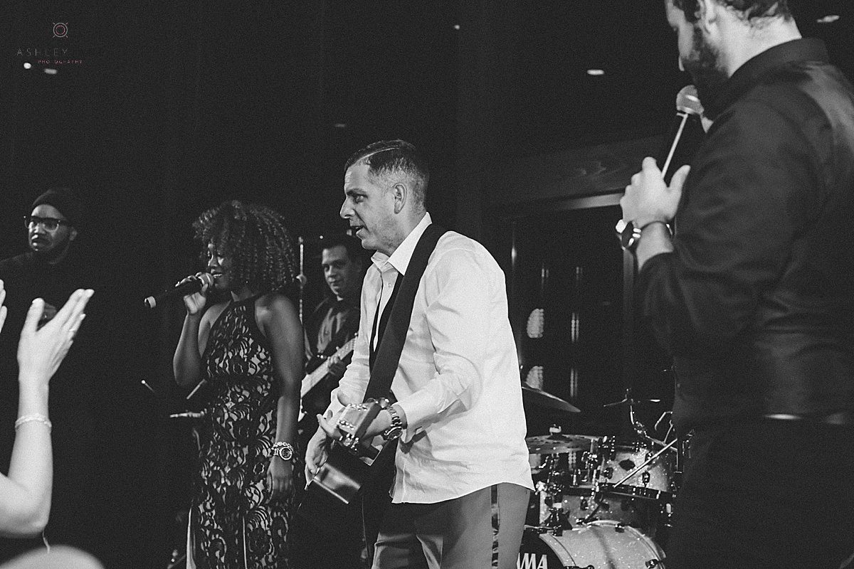 Groom jumping on stage with the band of his wedding shot by orlando wedding photographer